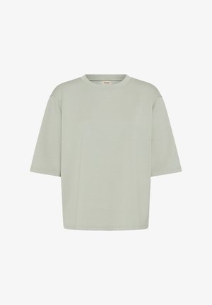 Maglietta oversize di colore grigio chiaro uniforme, a maniche corte, con scollo rotondo e cuciture visibili sulle maniche e sull'orlo.