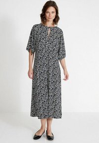 Blumenmuster-Kleid knielang in Marineblau und Weiß. Merkmale sind ein runder Ausschnitt, ein Schlüssellochdetail und lockere, kürzere Ärmel. Leichter Stoff.