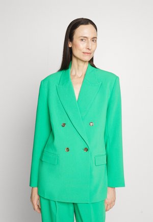Groene dubbelgeknoopte blazer van textuurstof met glanzende gouden knopen, grote revers en twee voorzakken, gestyled met bijpassende broek.