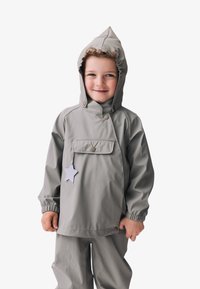 Graue wasserdichte Jacke mit Kapuze, ausgestattet mit elastischen Bündchen, einer Fronttasche und einem dekorativen Sternenetikett. Glatte Textur und praktisches Design.