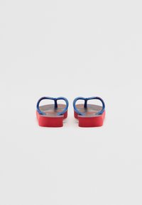 Røde og blå flip-flops med en teksturert såle, tynne stropper og et subtilt mønster på innsiden av sålen. Lett design for komfort.