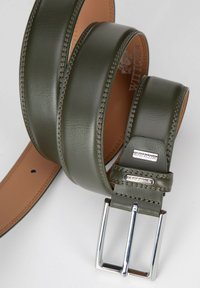 Cinturón de cuero verde con una textura suave, que presenta una hebilla de metal plateado y acentos de costura. El interior es de un color marrón claro en contraste.