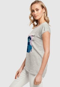 Grå bomulds t-shirt med grafisk tryk af en mand i blå med teksten "MONET" ovenfor og beskrivelser nedenfor. Korte ærmer, afslappet pasform.