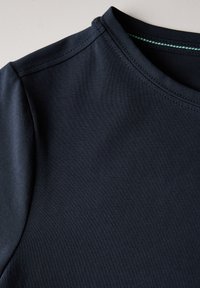 Námorně modré tričko s kulatým výstřihem, krátkým rukávem a hladkým, elastickým materiálem. Obsahuje jemný zelený akcent v límci.