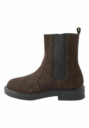 Braune Wildleder-Stiefelette mit einem schwarzen elastischen Einsatz, runder Zehenform und flacher Gummisohle. Verfügt über einen Schlaufeneinsatz an der Rückseite für ein einfaches An- und Ausziehen.