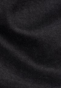 Tela negra con una textura suave, que presenta un patrón de tejido diagonal y un brillo sutil, típico de un material de algodón o denim de alta calidad.