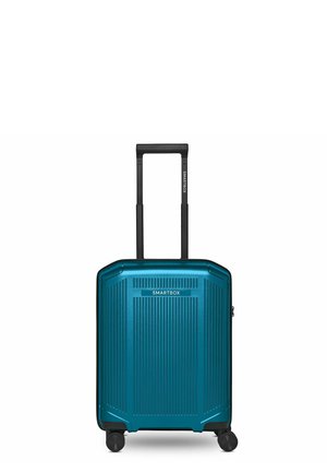 Maleta rígida azul con cuatro ruedas giratorias negras, estrías verticales y un asa telescópica negra con la etiqueta "SMARTBOX".