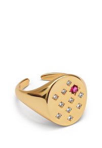 Pulsera de puño de color dorado con un acabado liso, adornada con nueve piedras preciosas transparentes y una piedra preciosa central de color rosa. Diseño redondo y abierto por ambos extremos.