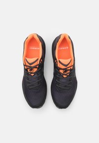 Black athletic shoes with orange accents, featuring textured mesh material, a padded collar, and rubber soles with lace-up design.