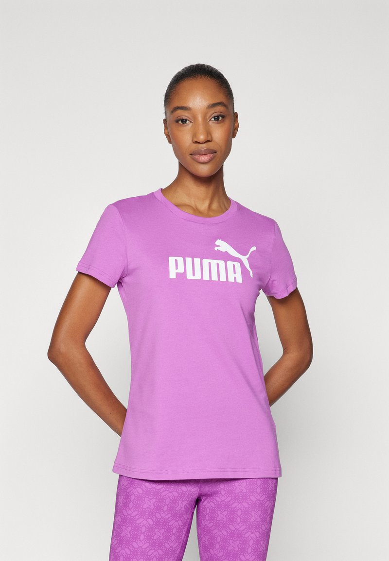 Violetinis medvilninis marškinėlis su trumpomis rankovėmis ir apykakle, kuriame yra didelis baltas "PUMA" logotipas ir mažas Puma katės grafikas.