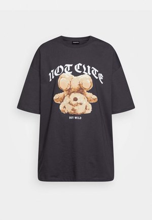 Black oversized t-shirt featuring a graphic of a bear with the text “NOT CUTE BUT WILD” in bold, white lettering. Cotton material.