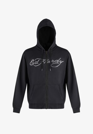 Black zip-up hoodie featuring a large, silver scripted "Ed Hardy" logo. Two front pockets, adjustable drawstrings on the hood. Soft fabric texture.