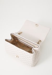 Quilted white handbag with a gold snap closure. Interior features a zip pocket and green brand logo lining. Adjustable chain strap included.