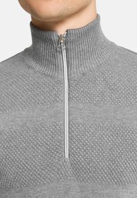 Grau pullover mit hohem geripptem Kragen und zentralem Reißverschluss. Verfügt über strukturierte Muster mit glatten Abschnitten und einer figurnahen Passform.