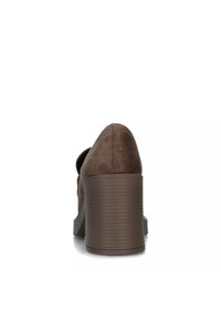 Scarpa con tacco alto in suede marrone, con un tacco a blocco testurizzato e un design posteriore arrotondato. La suola è liscia e leggermente curvata.