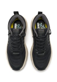 Zapatillas deportivas negras con parte superior de malla texturizada, acentos grises, cordones planos y una suela beige acolchada. Presenta un logo en la lengüeta.
