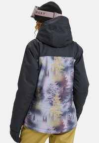 Black ski jacket with a hood featuring a colorful forest pattern on the back. Material appears smooth, with a relaxed fit and long sleeves.