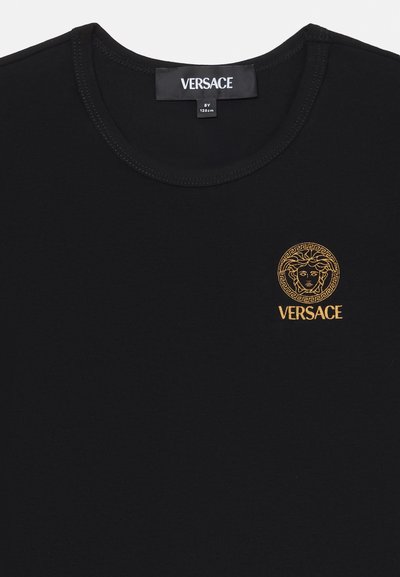 Černé bavlněné tričko s vyšitým zlatým logem Versace a kruhovým designem Medusy. Kolo výstřih a krátké rukávy.