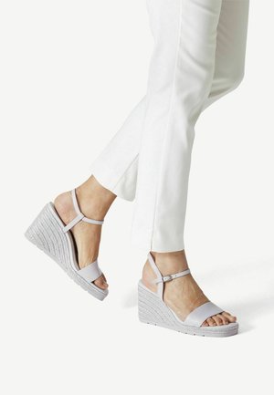 Sandales compensées gris clair avec une semelle tissée texturée, une bride de cheville et un design ouvert au niveau des orteils. Matériau supérieur lisse avec des accents minimalistes.