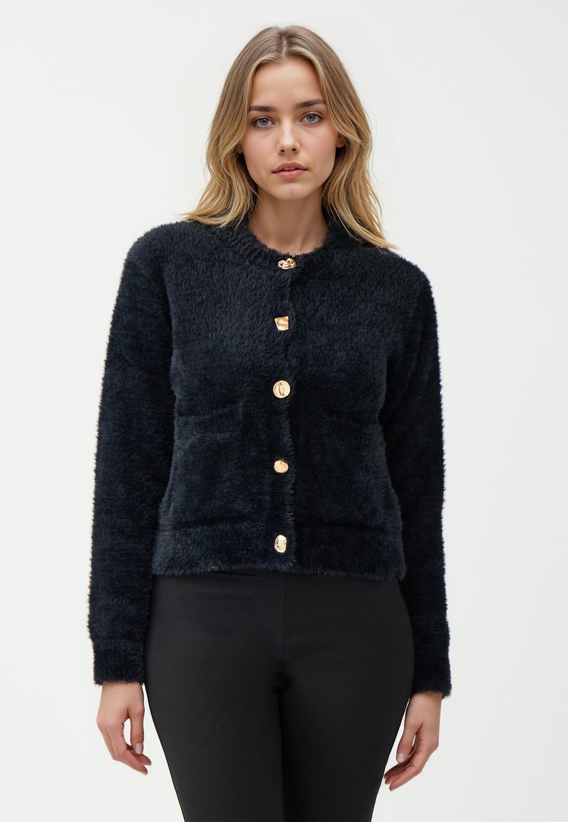 Cardigan nero e fluffy con colletto rotondo e cinque bottoni dorati davanti. Presenta maniche lunghe e una silhouette aderente.