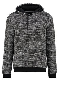 Huvtröja i en strukturerad svart och vit stickning; har dragsko, ribbade ärmslut och nederkant, med en slät innerfoder.