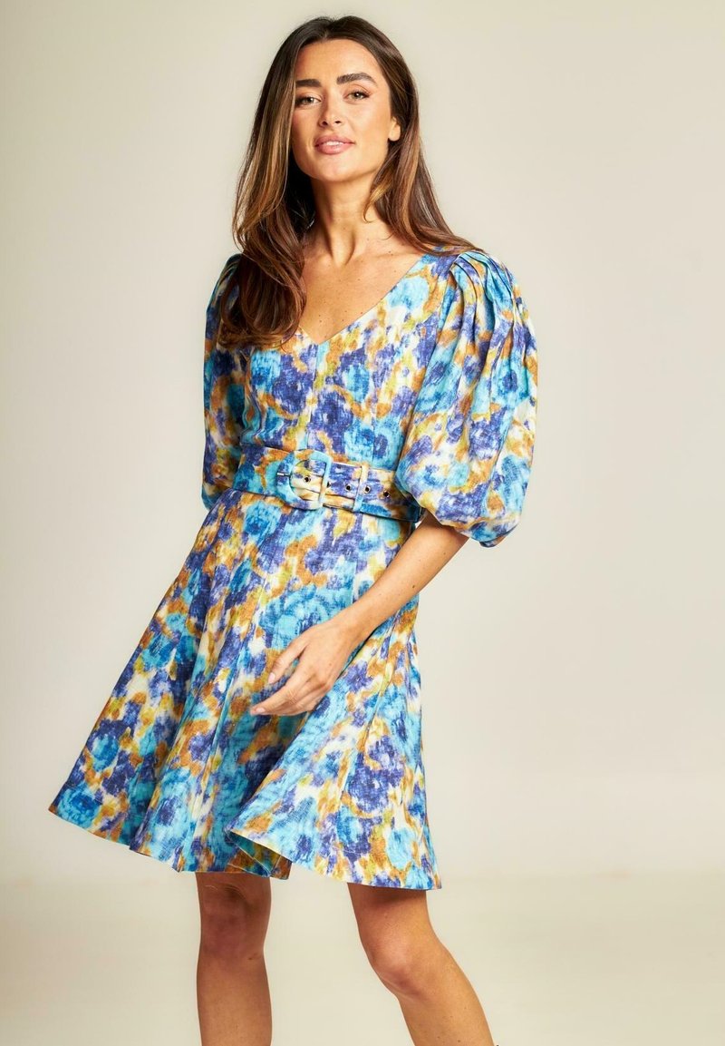 Blumenmuster-Kleid mit V-Ausschnitt, Puffärmel, tailliertem Bund und lebendigen Blau-, Orange- und Gelbtönen auf leichtem Stoff.