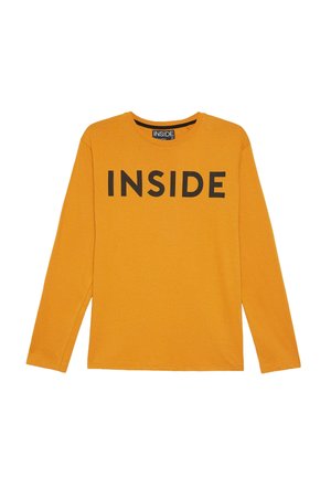 Camiseta de manga larga naranja hecha de algodón suave, con un prominente texto negro "INSIDE" en la parte frontal y un cuello redondo.