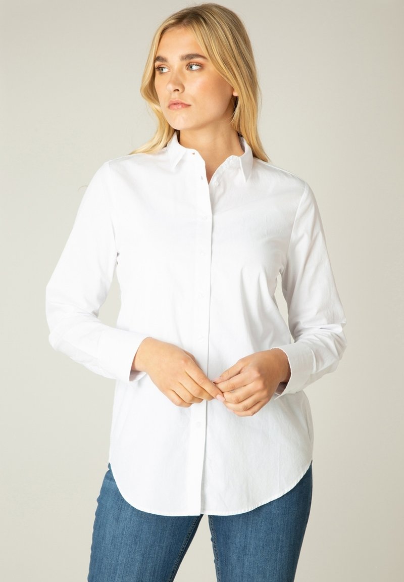 Witte lange mouw blouse met een kraag, met een rechte zoom en gladde katoenstof, gecombineerd met blauwe jeans.