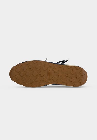 Semelle de chaussure avec une bande de roulement en caoutchouc marron présentant des motifs de feuilles d'érable et un petit logo rectangulaire au centre indiquant "DSQUARED2."