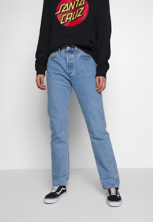 Jeans azzurri chiaro a gamba dritta in tessuto denim, con vita alta e design classico a cinque tasche, abbinati a una felpa nera con stampa grafica.