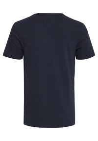 Tricou din bumbac bleumarin, cu guler rotund, mâneci scurte și un design simplu, având o cusătură orizontală subtilă pe spate.