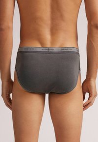 Szare dopasowane bokserki wykonane z elastycznego materiału. Posiadają miękką gumkę w pasie z logotypem „intimissimi” oraz bezszwową konstrukcję dla maksymalnego komfortu.