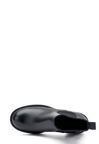 Botín de cuero negro con una textura suave, puntera redondeada, paneles laterales elásticos y una lengüeta para facilitar el uso. Suela de goma.