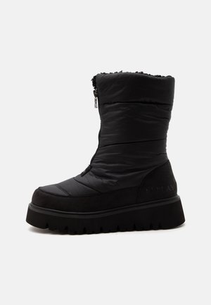 Botte d'hiver noire mi-mollet avec semelle épaisse, dessus matelassé, fermeture éclair à l'avant et doublure douce à l'intérieur pour la chaleur et le confort.