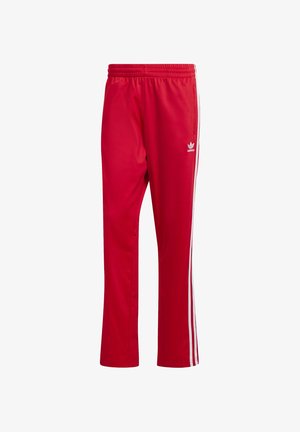 Rode sportbroek gemaakt van gladde stof met witte zijstrepen en een geborduurd logo op de linkerdij. Inclusief elastische tailleband.