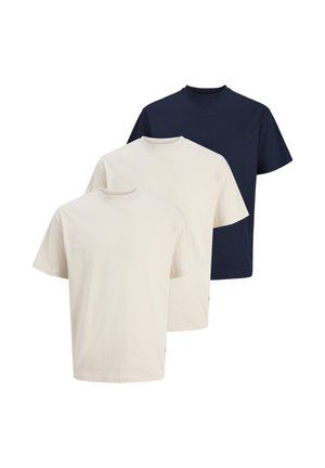 Tre t-shirt girocollo semplici, due in bianco sporco e una in blu navy, esposte su sfondo bianco.