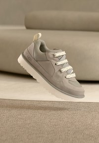 Baskets gris clair avec mélange de matériaux en suède et en mesh. Présentent des accents texturés, des lacets ronds et une semelle en caoutchouc blanche.