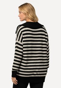 Gestreifter Pullover mit schwarzen und cremfarbenen horizontalen Streifen, einem hohen Kragen und einer lässigen Passform. Stricktextur mit gerippten Bündchen und Saum.