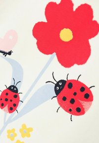 Tessuto bianco con un fiore rosso al centro giallo, due coccinelle rosse con macchie nere e piccoli fiori gialli con accenti blu.