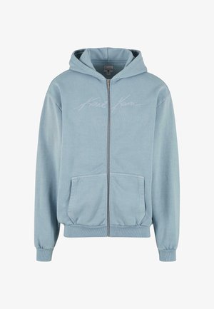 Šviesiai mėlynas zip-up modelio džemperis su priekinėmis kišenėmis, su raukinėtais rankogaliais ir apačia, su siuvinėtu "Karl Kani" logotipu ant krūtinės.