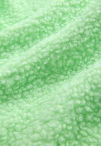 Soft, textured fabric in a light mint green color with a fuzzy, plush surface that features small, rounded fibers for added depth.