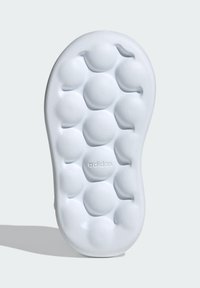 Adidas white shoe sole featuring a textured bubble pattern, smooth finish, and embossed logo. Rounded shape with raised cushioning sections.