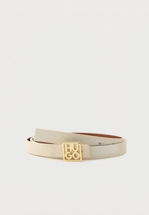 Cream-colored leather belt coiled flat with gold square buckle displaying "HUGO" logo on plain white background.