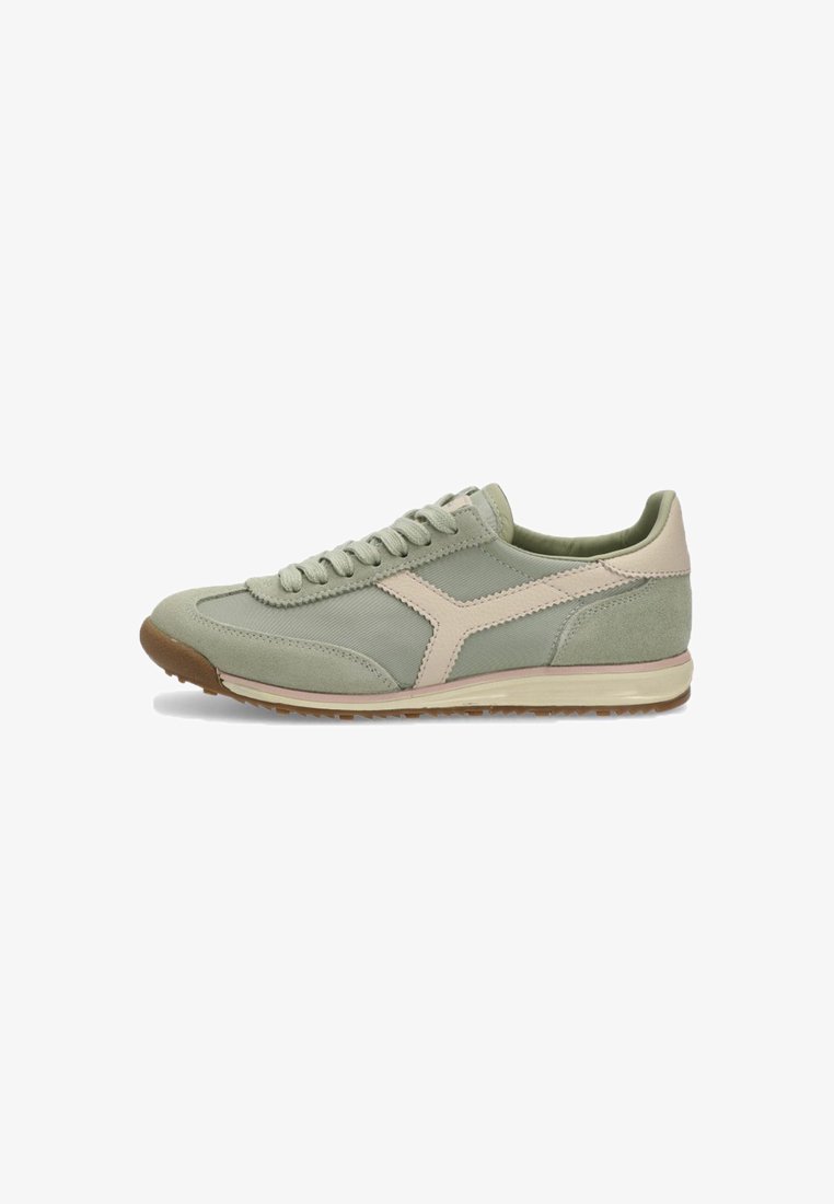 Zapatilla atlética verde claro con una mezcla de materiales superiores lisos y texturizados, que presenta un acento rosa pálido y una suela de goma marrón.
