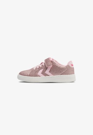 Pink glitzernde Turnschuhe mit einem Klettverschluss, versehen mit pinken Akzenten und zwei pinken Zickzack-Designs an der Seite, auf einer weißen Sohle.