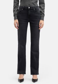Czarne jeansy z denimu o prostych nogawkach i średnim stanie, z pięcioma kieszeniami, subtelnymi przeszyciami oraz lekkim spraniem dla uzyskania tekstury.