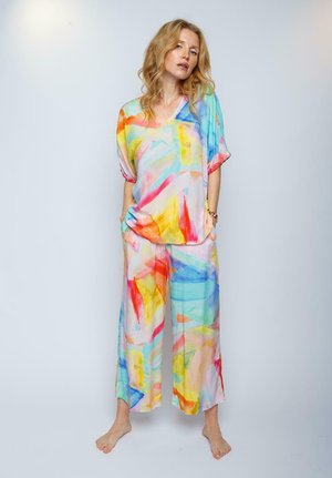Buntes, lockeres Outfit aus leichtem Stoff mit abstrakten Mustern in Pink, Gelb, Blau und Grün und einem V-Ausschnitt-Design.