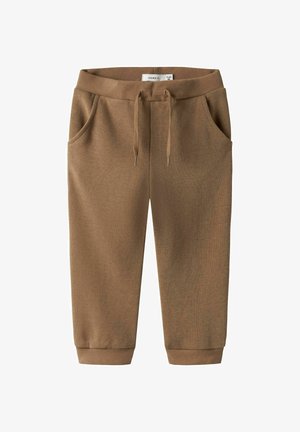 Brown ribbed sweatpants with an elastic waistband, adjustable drawstring, and side pockets. Cuffs at the ankles provide a fitted look.