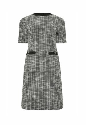Robe tissée en noir et blanc, avec des manches courtes, un col rond, deux poches avant avec des accents noirs et une jupe droite.