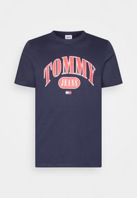 T-shirt de algodão azul-marinho com uma impressão em vermelho ousado de "TOMMY" e "JEANS". Design clássico com decote redondo e mangas curtas. Corte casual.